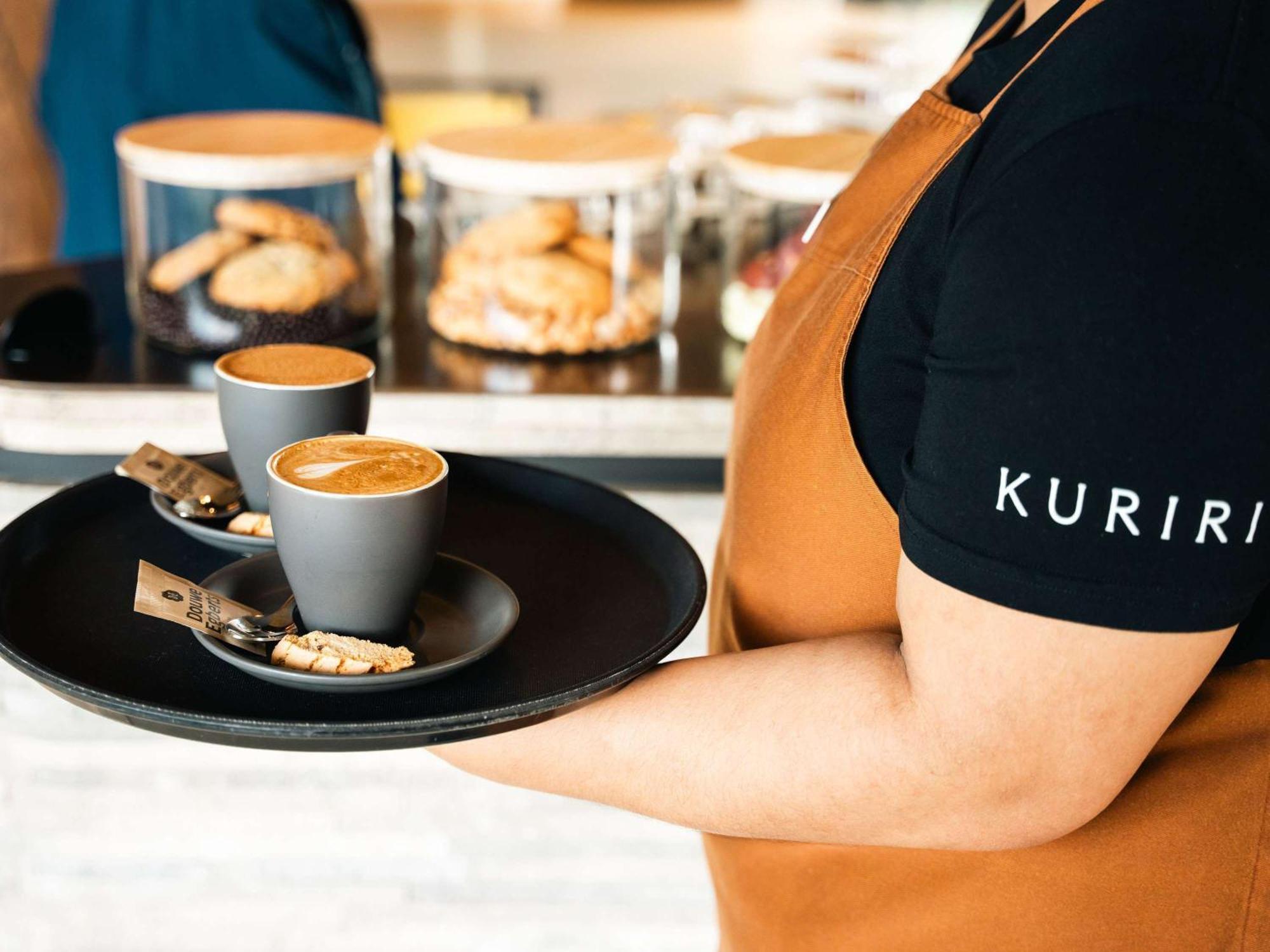 Pullman Auckland Airport Hotel Bagian luar foto A server holding a tray of coffee